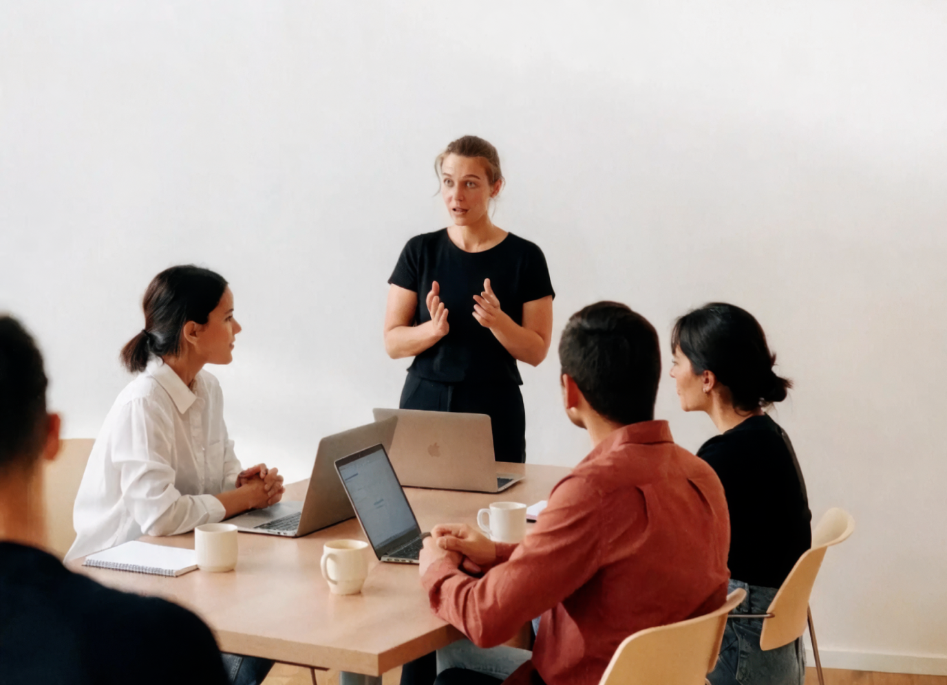 Persona explicando de pie a un grupo sentado con portátiles